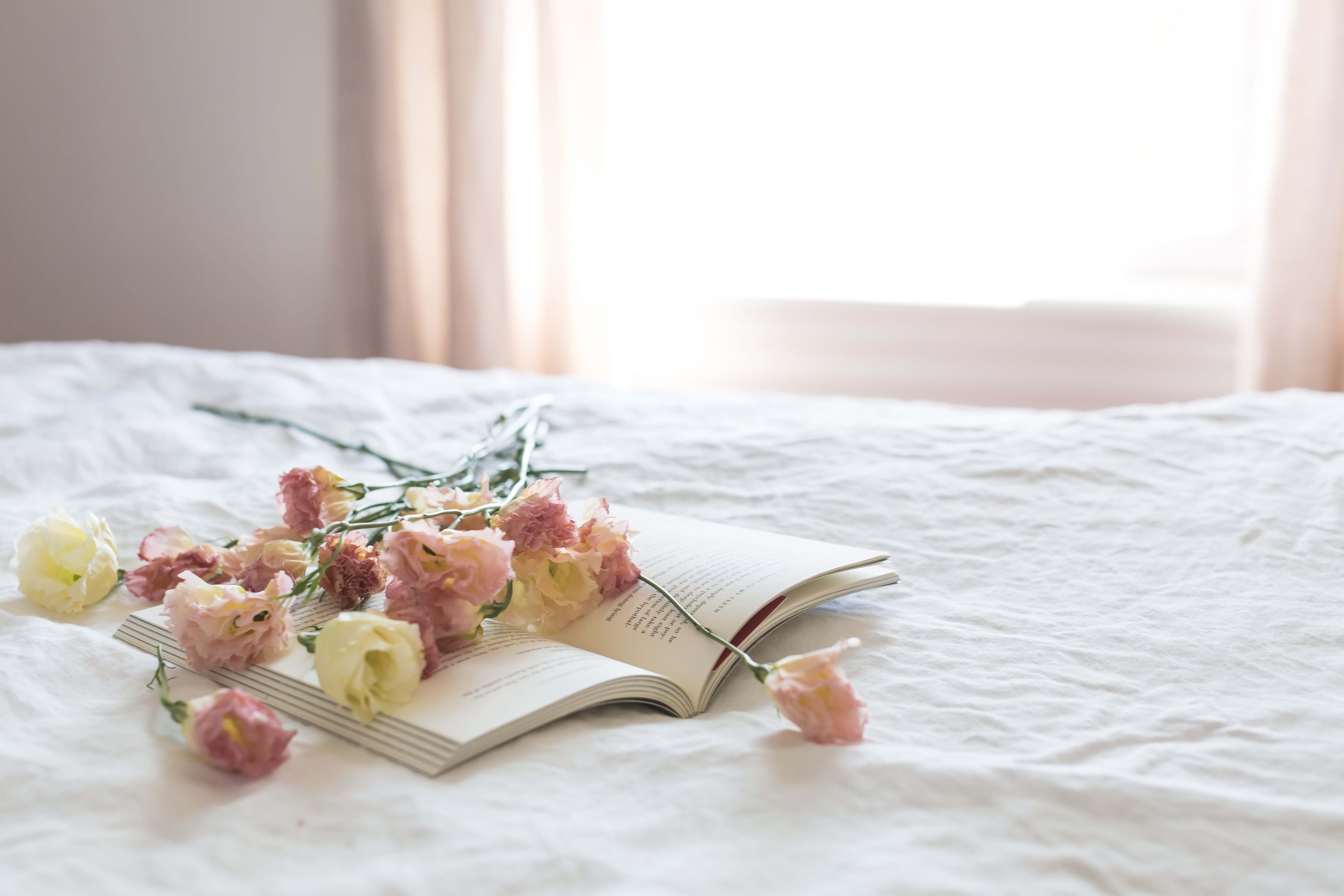Flowers laying on a book in a bedroom